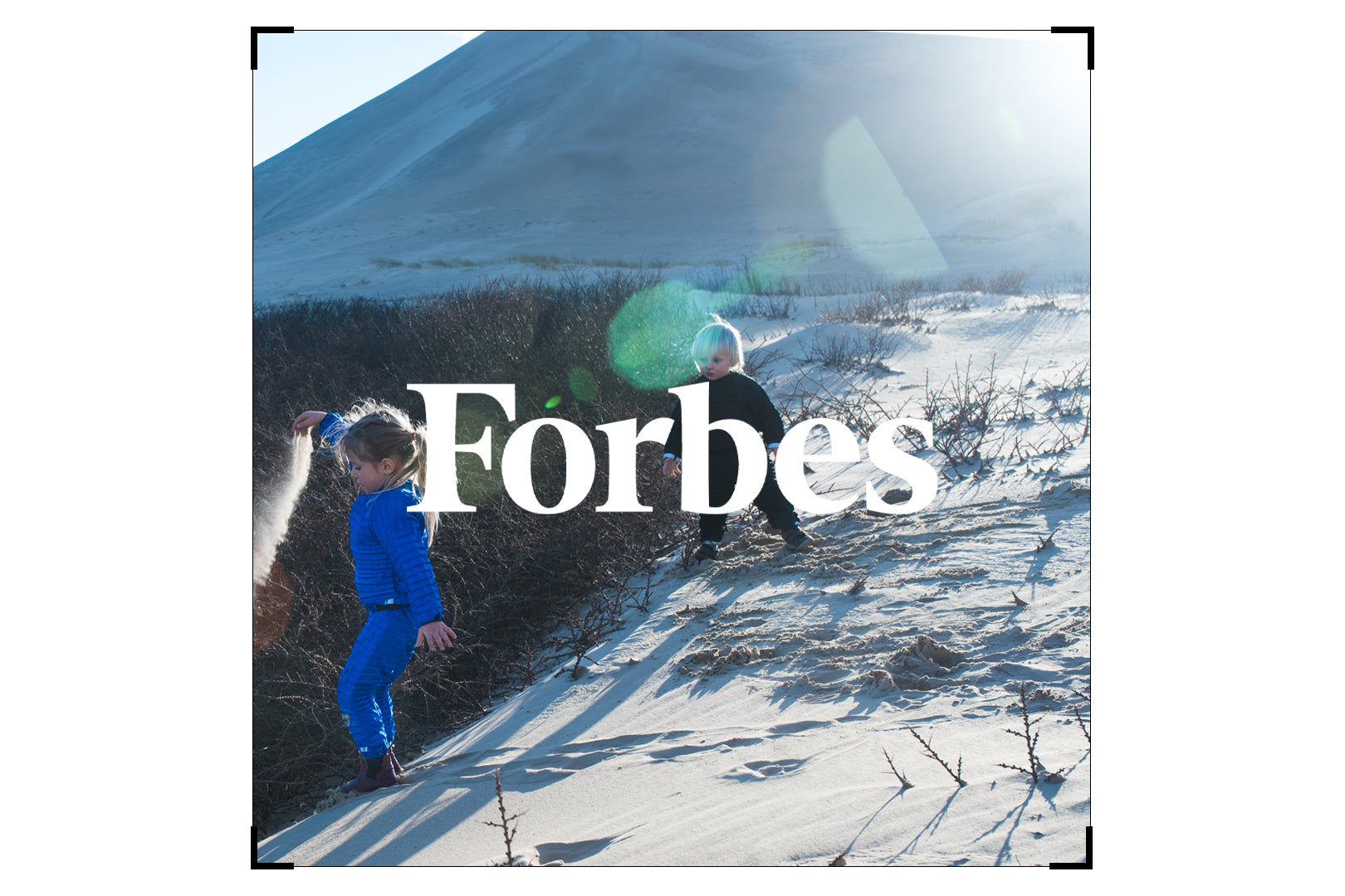 Photo of children playing in the snow wearing Petit Pli overlaid with a Forbes logo