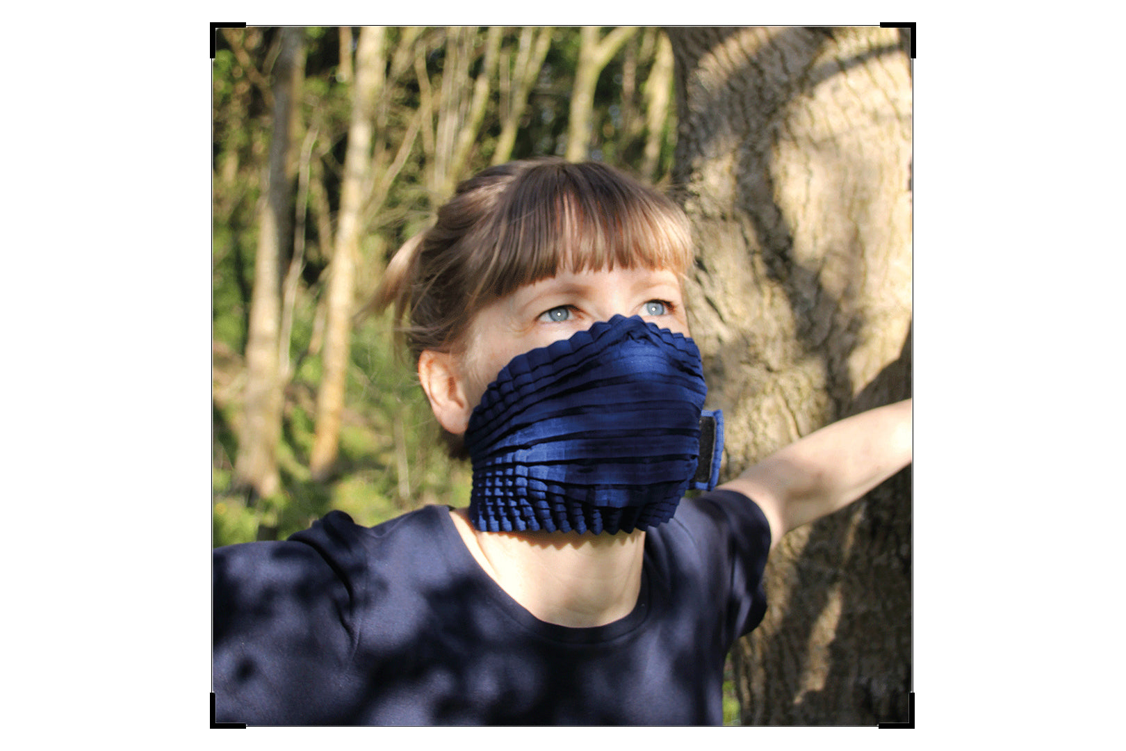 Portra Photograph of Leonora wearing her blue MSK amoung shadows from a tree scattered across her face