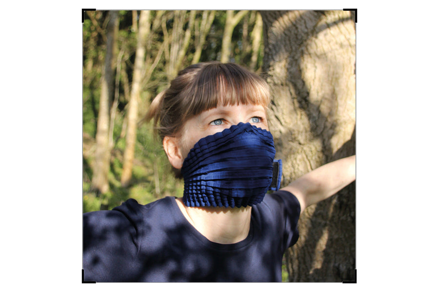 Portra Photograph of Leonora wearing her blue MSK amoung shadows from a tree scattered across her face