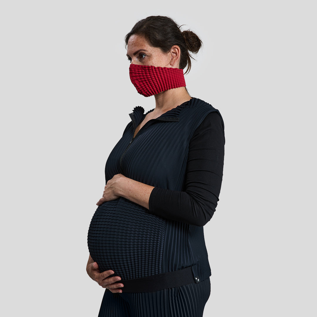 Pregnant Women models BETA Adultwear and red MSK, cradling her pregnant belly—symbolising adaptive design, inclusivity, and future-facing fashion.