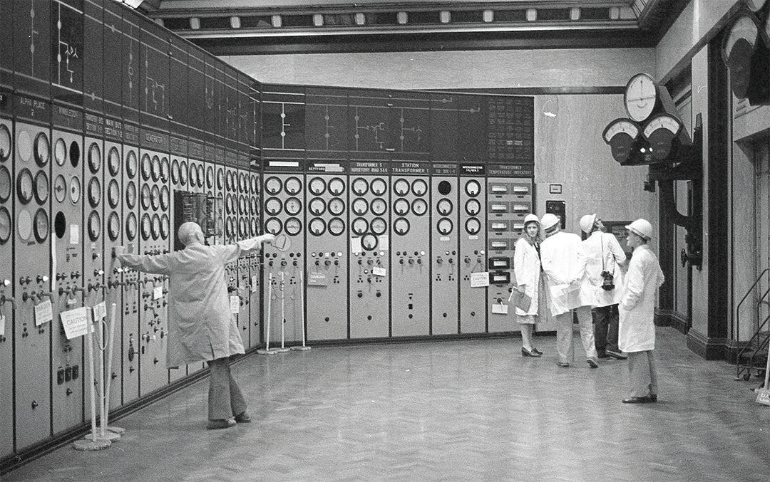 Historic control room at Battersea Power Station with dials and gauges, where engineers in white coats once managed the iconic London landmark.