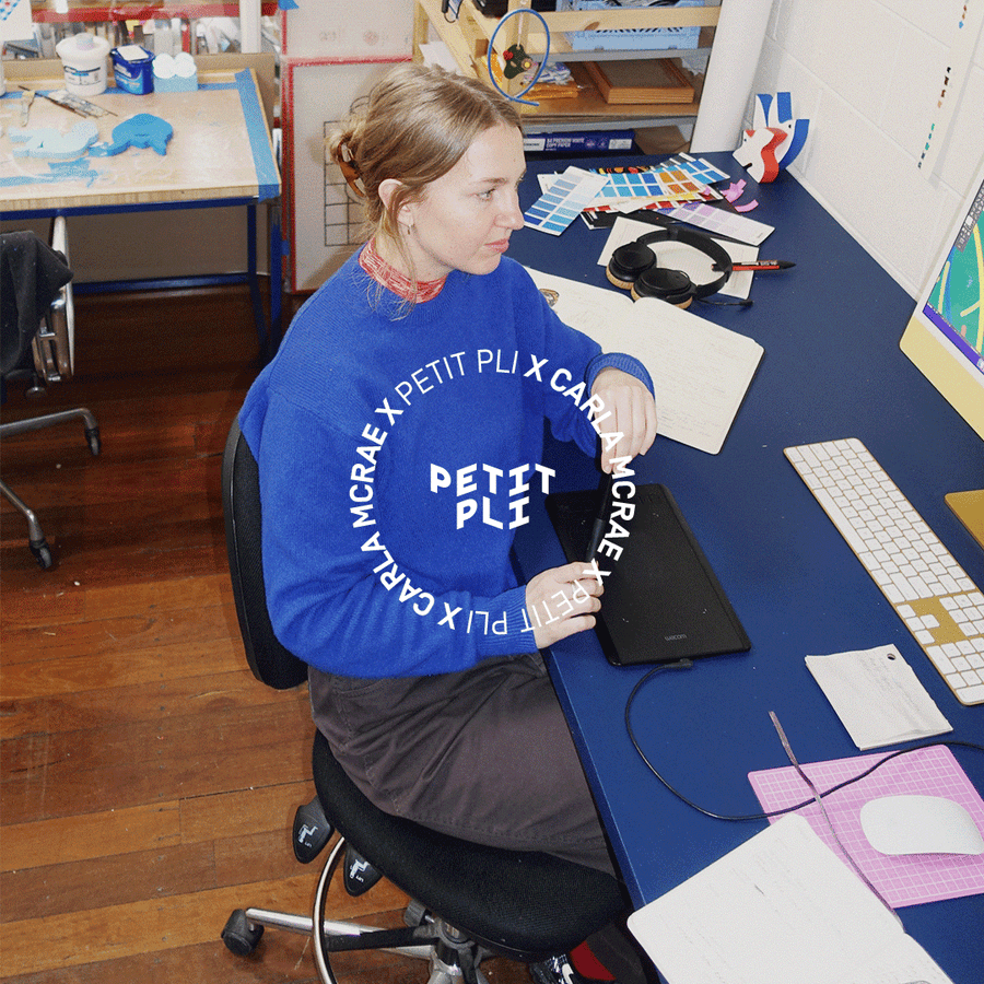 Carla McRae works at her studio desk, sketching digital illustrations for Petit Pli’s Grass Jungle print, inspired by nature and playful observation.