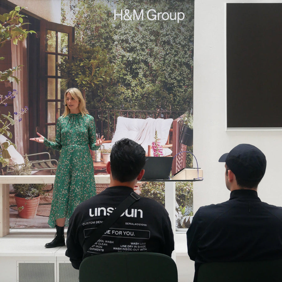 Helena in green dress presents at H&M Group’s Planet Positive Forum, sharing sustainable fashion insights with seated audience.