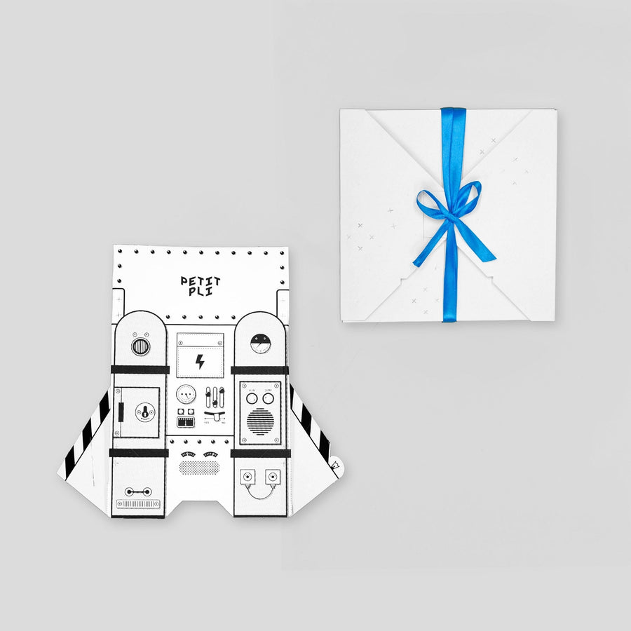 Petit Pli Jetpack Packagaing shown with playful spaceship control panel design, a zero waste gift wrapped in blue ribbon to inspire imaginative LittleHuman adventures.
