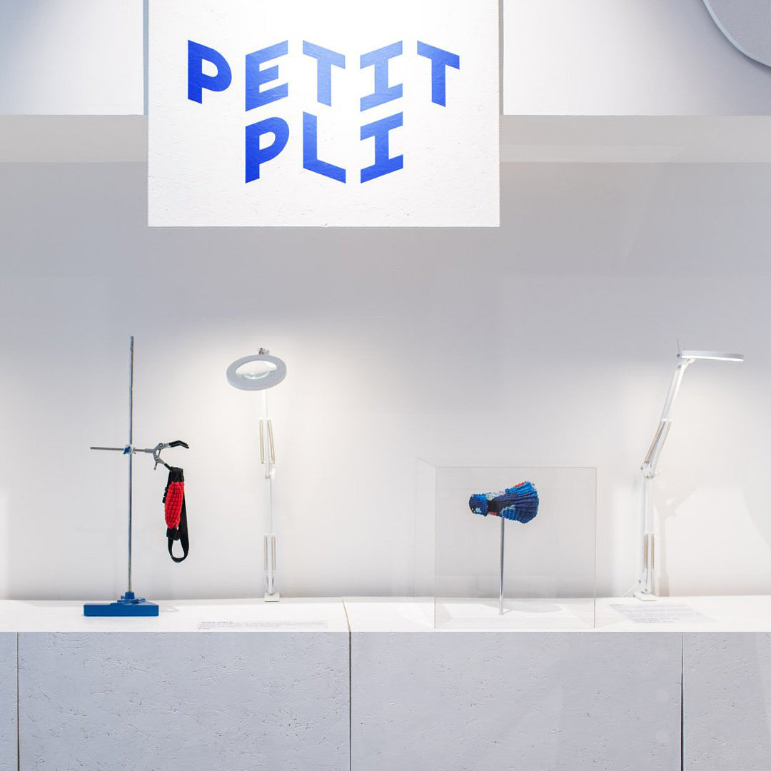 Petit Pli display at Regent Street Edit featuring innovative garments, design tools, and brand signage on a clean white stand