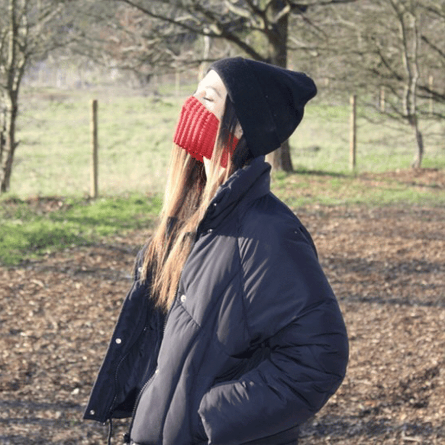 Kat stood in nature listening for birds as a form of meditation wearing her Infrared Petit Pli MSK