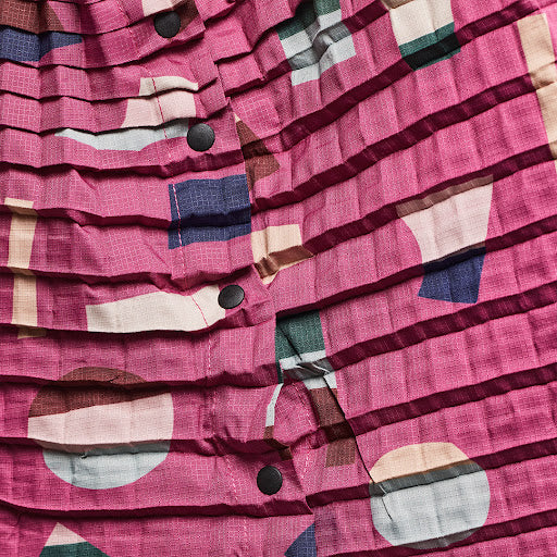 Close-up of Petit Pli x Jonathan Lawes Print 03 pleated fabric, featuring bold geometric shapes and colours